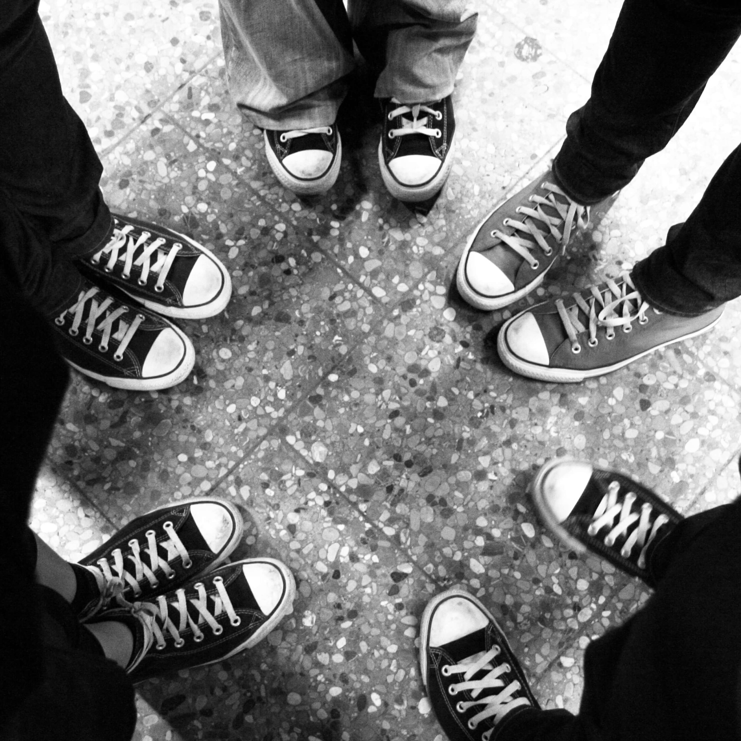 Schuhe von einer Personengruppe, die in einem Kreis stehen